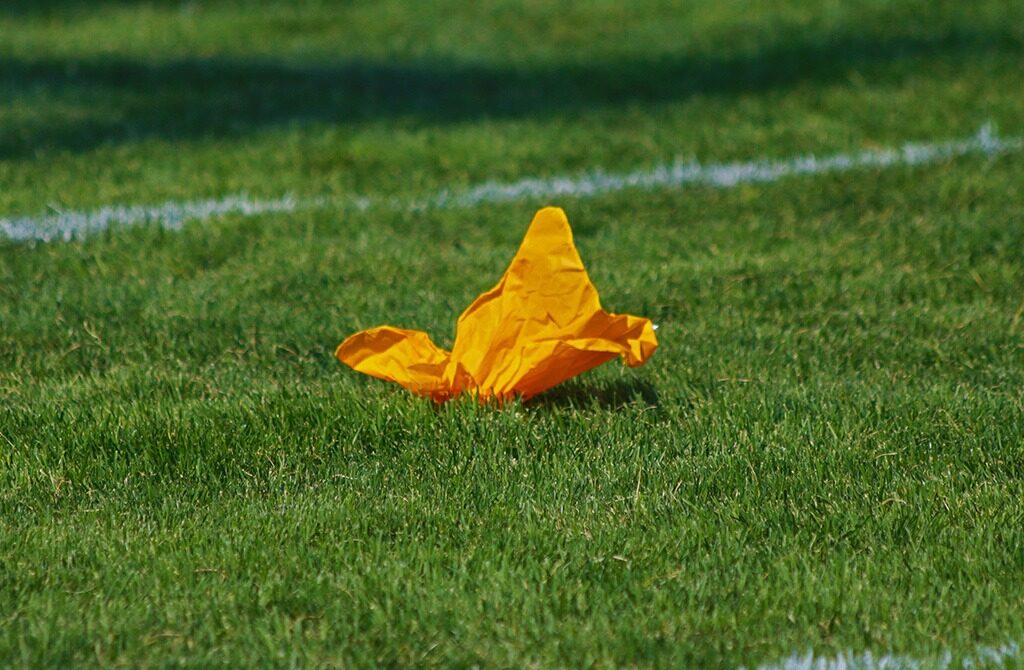 gelbe flagge eines Schiedsrichters auf dem rasen