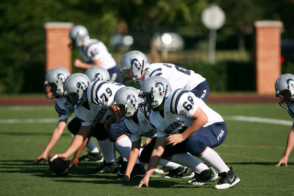 Das Bild zeigt die Offense eines American Football Teams kurz vor dem Snap